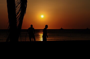 Amateurs playing football at Jumeira beach in Santa Marta, Colombia during sunset.