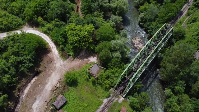 Flight over the fiver and railway metal green bridge over the river. Aerial bird view 