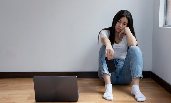 Sad, Pensive Young Girl With Her Cell Phone About To Fall To The Floor