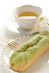Green tea eclair puff cream confectionery on white dish with copy space