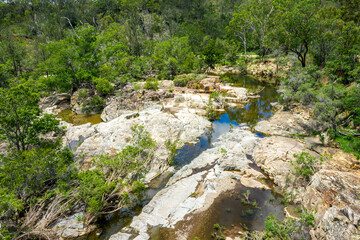 Kroombit Tops National Park summer landscape with fresh water creek and swimming hole and vribrant green vegetation, Queensland