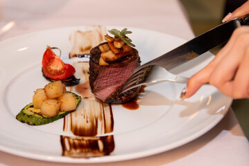 Hand slicing a steak meat on a fine dining restaurant.