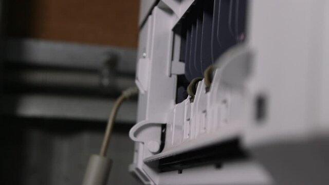 A printed sheet of A four paper coming out of a laser printer.