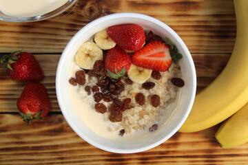 Oatmeal with fruits on a wooden table