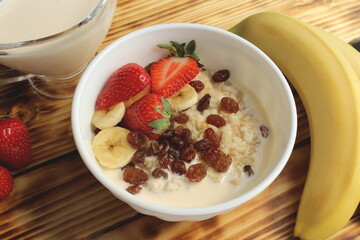 Oatmeal with fruits on a wooden table
