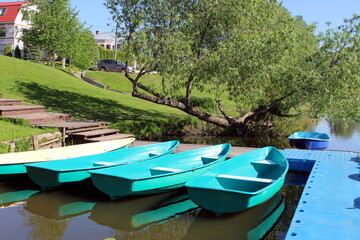 Obraz premium several boats moored to a small bridge by the river