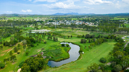 Vibrant green summer landscape showing a golf course and hills in the distance, in Calliope, Queensland