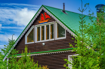 Two-storey house made of wood in the forest in summer.
