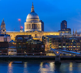 Naklejka premium View of the famous St. Paul's Cathedral across the river Thames with Millennium Bridge in London, England