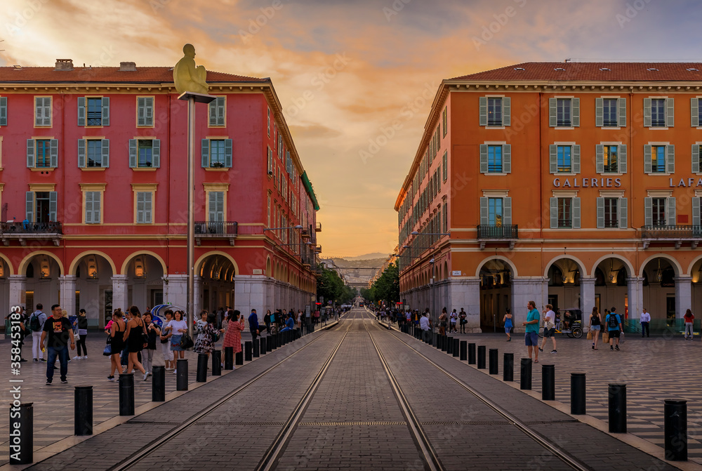 Wall mural tourists visit place massena, major commercial and cultural landmark in nice at sunset golden hour i