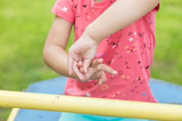 hands of a child close-up who is trying to put the number three on the fingers.