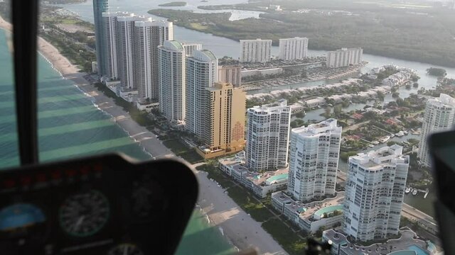 Aerial helicopter view of buildings on Miami Beach skyline in evening sunlight