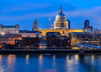 View of the famous St. Paul's Cathedral across the river Thames with Millennium Bridge in London, England