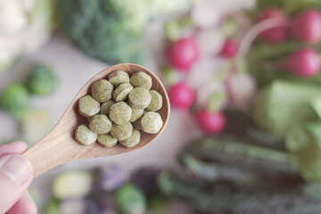Cruciferous vegetables tablets in wooden spoon, dietary fiber prebiotic supplements for healthy gut