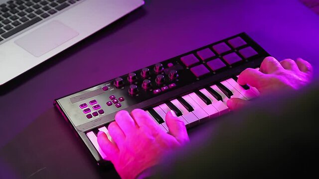 Male hands play customize the midi keyboard and play on the keys.
