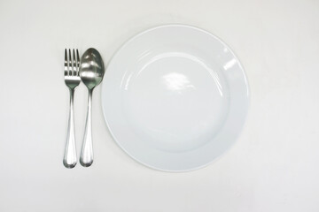 A white plate with a practice spoon placed on a white background