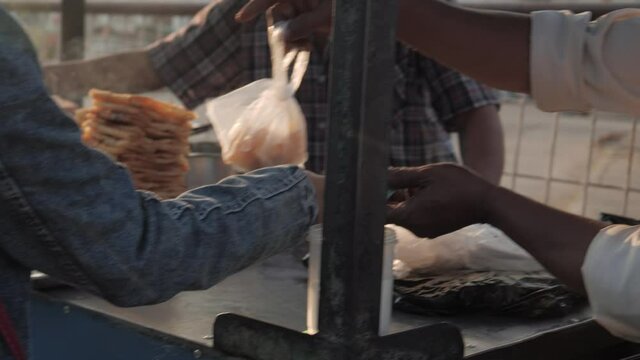 Woman paying cash for fresh street food early in the morning,slow motion shot