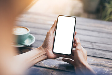 cell phone mockup image blank white screen.woman hand holding texting using mobile on desk at coffee shop.background empty space for advertise.work people contact marketing business,technology