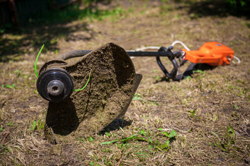 The lawnmower is lying on the ground.