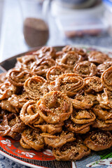 Homemade traditional moroccan sweets preparation with a woman hand´s forming the dough for the Ramadan chebakia.