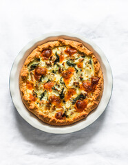 Tuna, mozzarella cheese, spinach, potatoes rustic simple pie on a light background, top view
