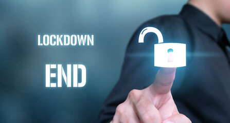 Businessman touches virtual lock icon means to end lockdown in covid 19 period. covid 19 concept ,...