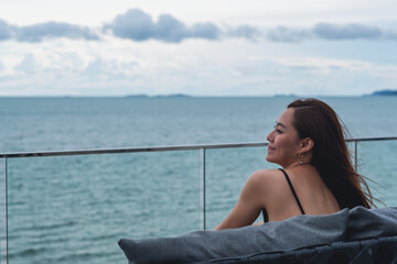 A beautiful young asian woman looking at the sea and blue sky view
