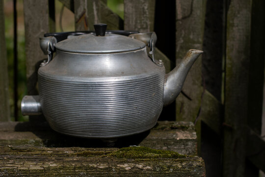 Old Aluminum Kettle On A Wooden Bench.