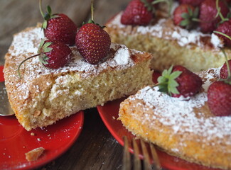 Pastry background. Banana sponge cake with strawberries at the top with a cut piece. Home cooking.