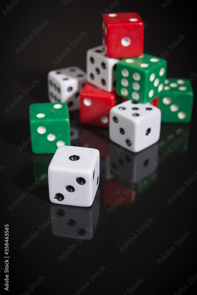 Wall mural multi-colored dice on a black surface