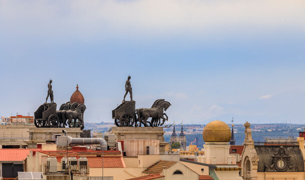 Madrid, Spain - June 4, 2017: City rooftops and neoclassical quadriga Roman Chariot statues on Banco Bilbao Vizcaya BBVA bank building built in 1923