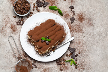 Classic tiramisu dessert on ceramic plate on concrete background