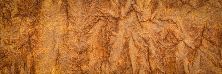 burnt sienna - background and texture of backlit handmade Nepalese momi lokta paper, panoramic banner