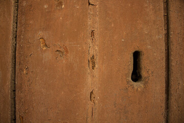 evocative texture image of an old wooden door with vertical axes and lock