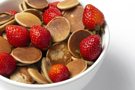 Homemade cereals mini pancake with yogurt, honey and strawberries on colorful background.