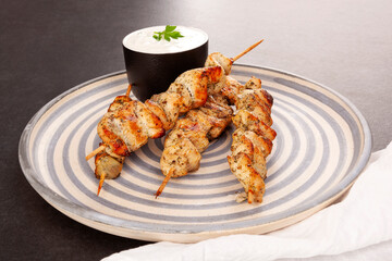 Bbq meat on wooden skewers on plate.