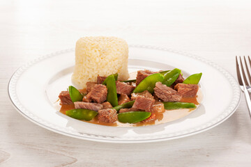 Beef meat stewed with baby peas and rice.