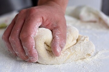 Fototapeta na wymiar Bread making process. Closeup of man hands kneading dough. Baker cooking pastry. Culinary courses and food preparation.