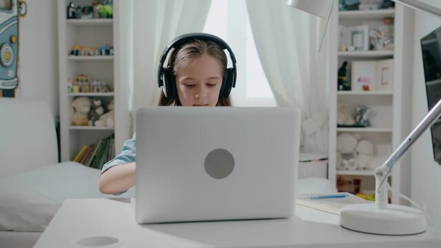 Beautiful girl student in headphone open laptop study online with internet teacher learn, distance education concept slow motion