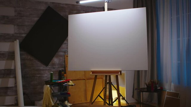 Empty beautiful artist studio with blank canvas on wooden easel. Modern artwork paint on canvas, creative, contemporary and successful fine art artist drawing masterpiece