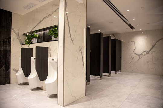 white urinals in a modern premium public restroom. men's toilet interior