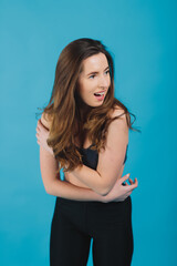 cheerful sports girl smiling and looking into camera on blue background