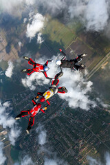 Fototapeta na wymiar Skydiving photo. Four sports parachutist build a figure in free fall. Extreme sport concept.