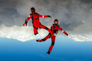 Skydiving photo. Two sports parachutist build a figure in free fall. Extreme sport concept.