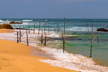 Fototapeta na wymiar Fishermen sticks on the Sand Coast of Sri Lanka.