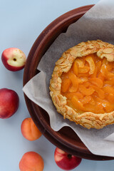 Baked galette or open apricot pie on the table. Homemade pastry