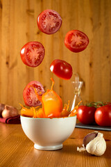Tomatoes falling in bowl of gazpacho splash selective focus