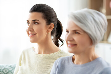 family, generation and people concept - portrait of happy smiling senior mother with adult daughter...