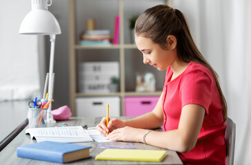 children, education and learning concept - student teenage girl with ruler drawing line in notebook...