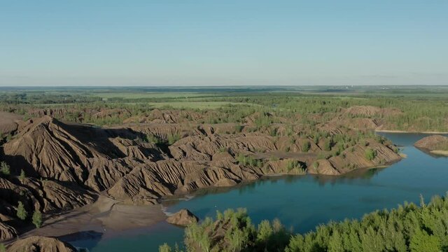 Romantsevo hills and lakes in Tula oblast drone aerial shot drone aerial pan shot zoom out. Fly over tulskaya oblast romantsevskie hills, konduki shot under cloudy blue sky